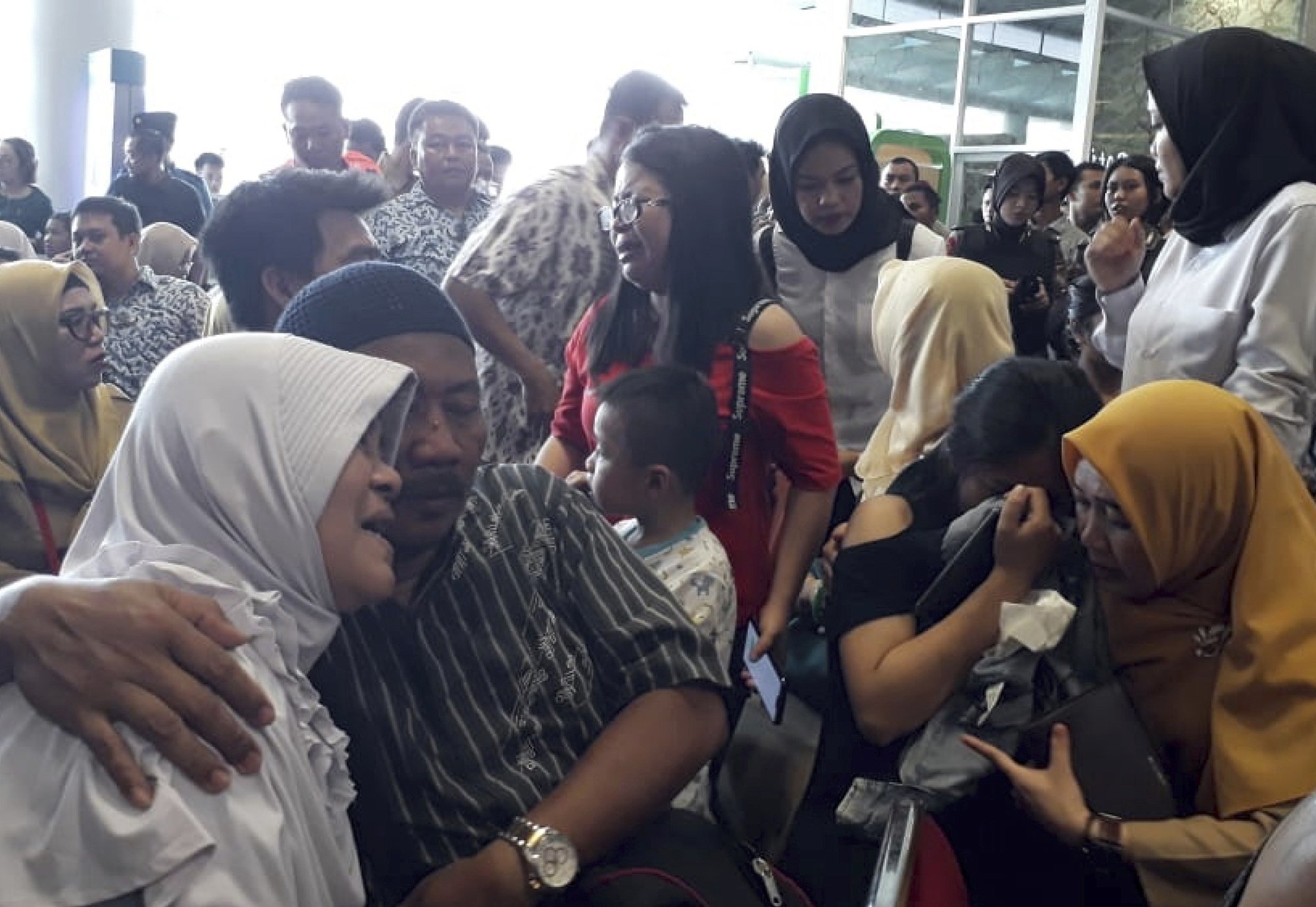 Relatives of passengers comfort each other as they wait for news on a Lion Air plane that crashed off Java Island at Depati Amir Airport in Pangkal Pinang on Monday. ─ AP