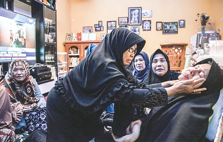 A CRYING woman (right) is being consoled after the loss of her husband, a passenger on board the ill-fated Indonesian plane which plunged into the sea soon after takeoff from Jakarta on Monday. All 189 passengers and crew on board were feared dead, the country&rsquo;s search and rescue agency said.&mdash;AFP