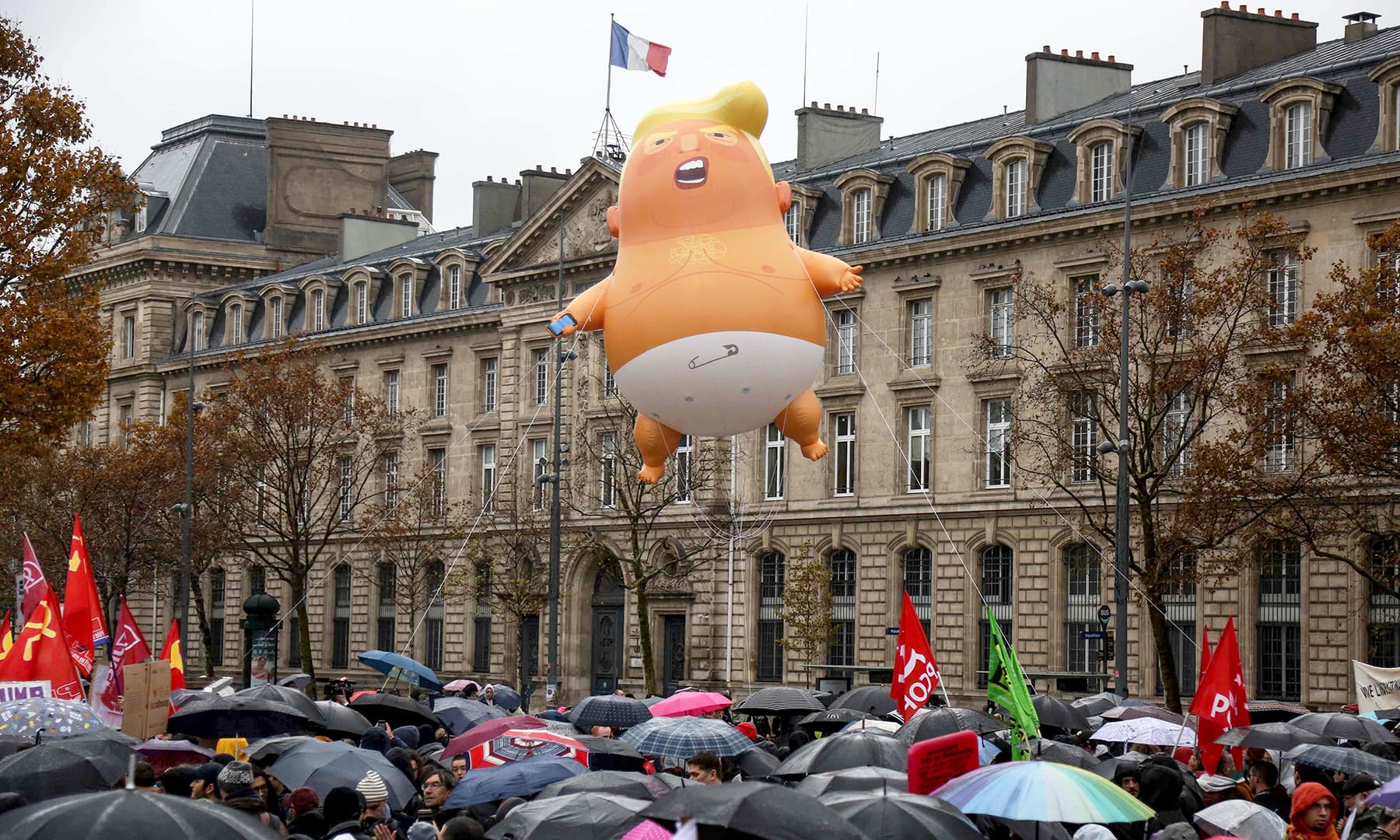 A balloon depicting the US President Donald Trump wearing a diaper, flies over the heads of people protesting against the US leader at the Place de la Republique in central Paris. —AFP