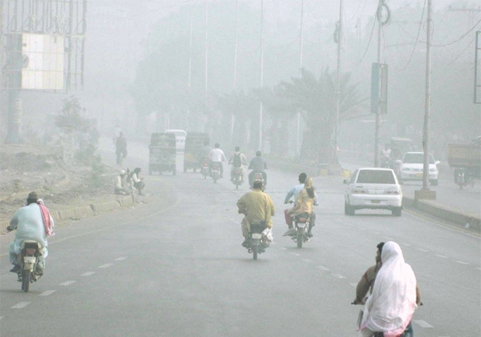 DRIVERS on a road face poor visibility as thick fog envelops Hyderabad on Monday evening.&mdash;PPI