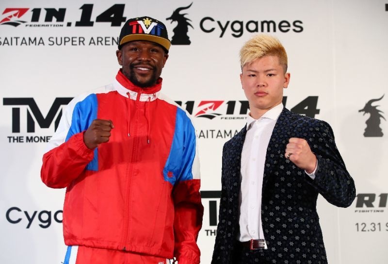 Mayweather poses alongside his opponent. &mdash; AFP