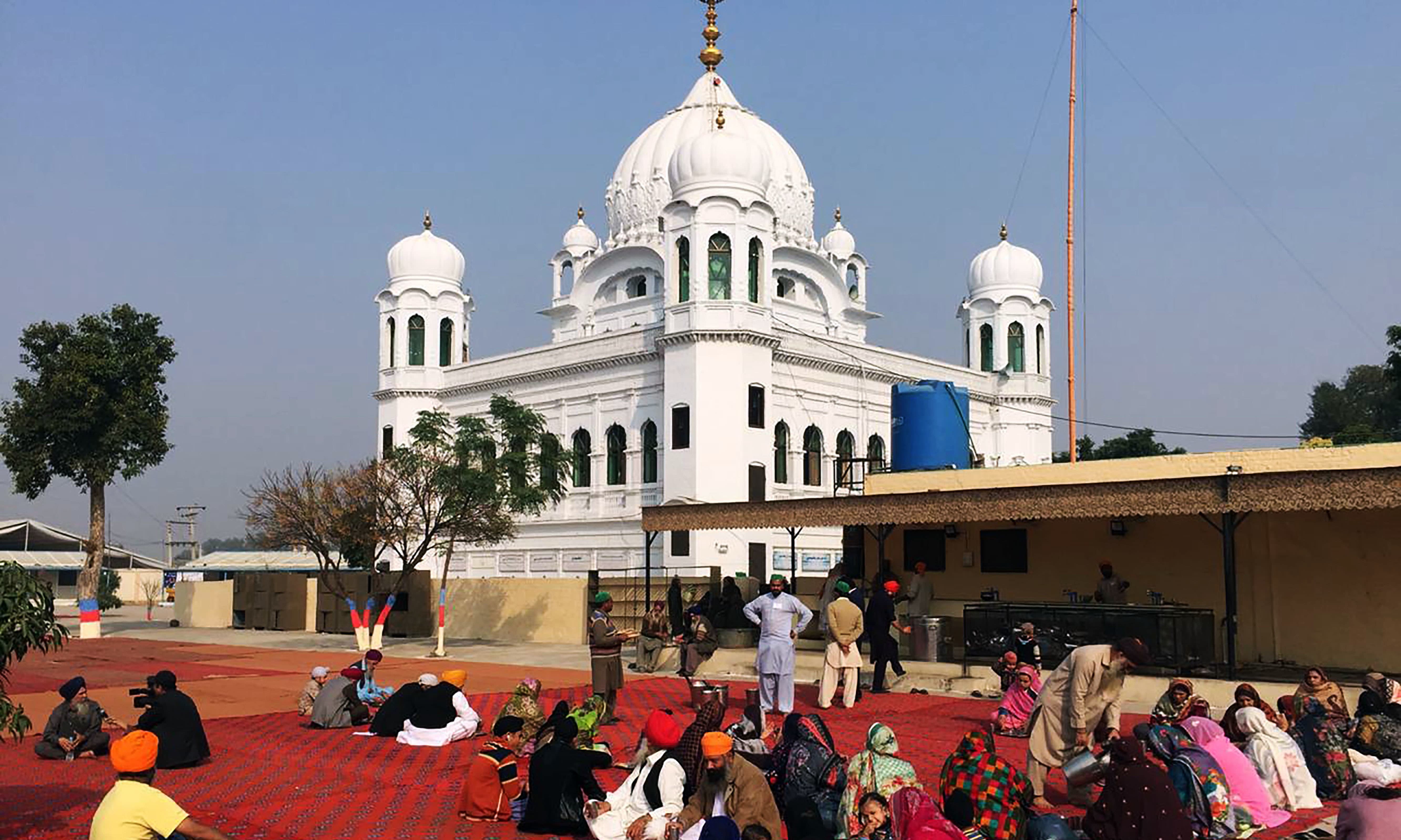 Sikh Pilgrims sit in front of Kartarpur Gurdwara Sahib before the groundbreaking ceremony of the Kartarpur Corridor. —AFP