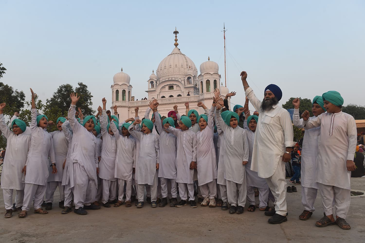 Sikh children shout slogans in front of the Kartarpur Gurdwara Sahib after the groundbreaking ceremony for the Kartarpur Corridor. — AFP