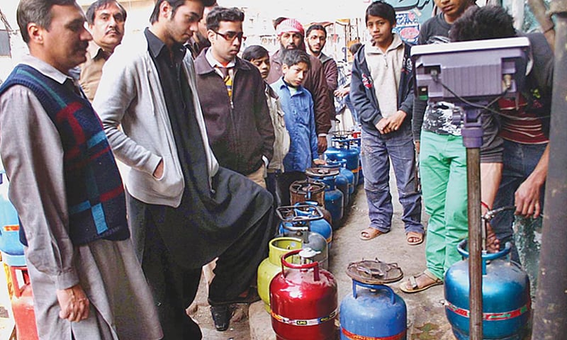 People stand in queue for filling up their LPG cylinders in Lahore.&mdash;File photo