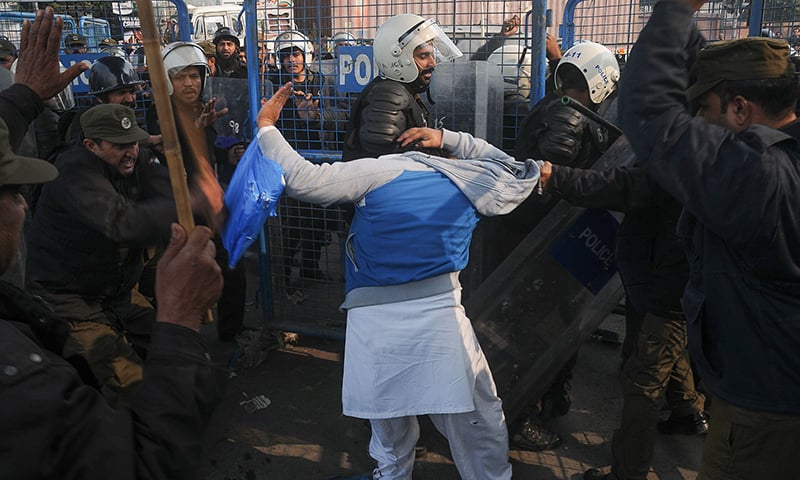 Policeman beat a supporter of arrested PML-N President Shahbaz Sharif on his arrival at an accountability court in Lahore. —AFP