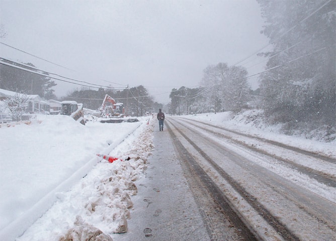 Wake Forest (North Carolina, US): A man trudges through blowing snow on Sunday.—AP