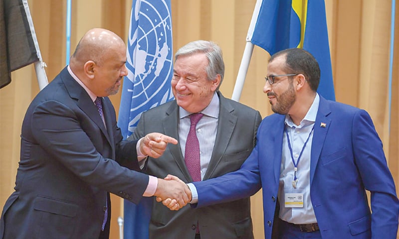 Yemeni Foreign Minister Khaled al-Yamani (left) and Houthi negotiator Mohammed Abdelsalam shake hands on Thursday. In the centre is a smiling United Nations Secretary General Antonio Guterres.—AFP