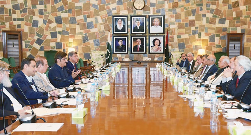 Sindh Chief Minister Syed Murad Ali Shah talks to Petroleum Minister Ghulam Sarwar Khan during a meeting at the CM House in Karachi on Friday.—PPI