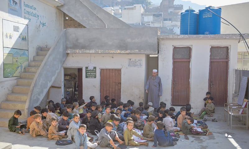Boys attend a class outside a school in Mingora.&mdash;AFP