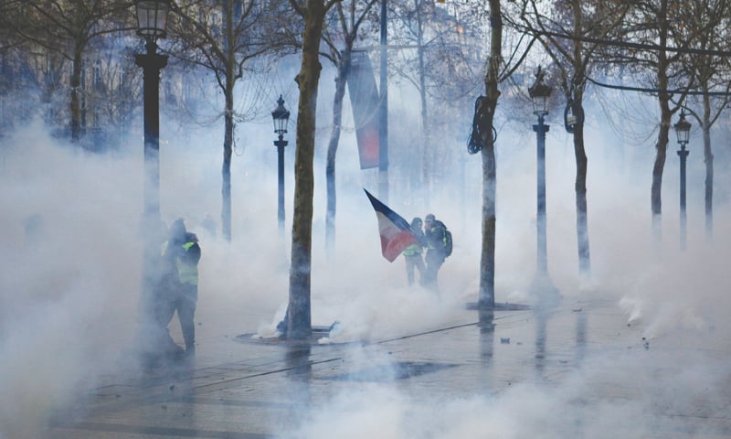 Paris: Demonstrators appear through tear gas during scuffles on the Champs-Elysees avenue on Saturday.—AP