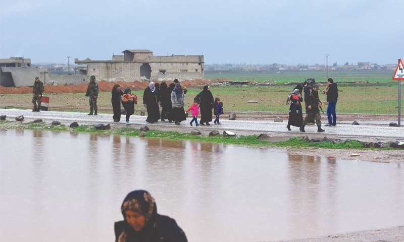 Syrian civilians cross from rebel-held areas in Idlib province into government-held territories.—AFP Syrian civilians cross from rebel-held areas in Idlib province into government-held territories.—AFP