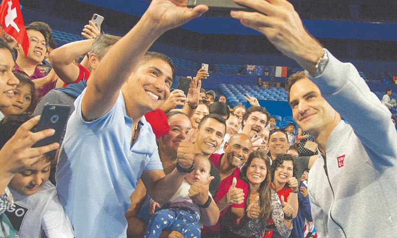 PERTH: Defending champion Roger Federer of Switzerland takes a selfie with fans after a practice session with Spain&rsquo;s David Ferrer on Friday.&mdash;AFP