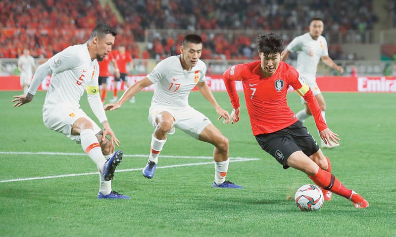 ABU DHABI: South Korea&rsquo;s Son Heung-Min controls the ball as China&rsquo;s Zhang Chengdong and Zhang Linpeng (L) look on during their Asian Cup Group &lsquo;C&rsquo; match at the Al Nahyan Stadium.&mdash;AP