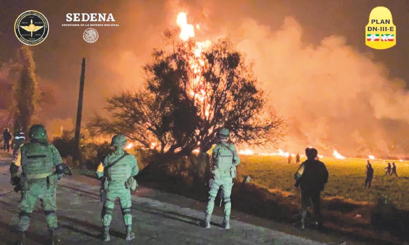 Tlahuelilpan: In this handout photo provided by Mexico&rsquo;s National Defence Secretary (SEDENA) military personnel watch as flames engulf an area 
near the Tula refinery of state oil firm Petroleos Mexicanos after a ruptured fuel pipeline exploded 
on Friday evening.&mdash;Reuters