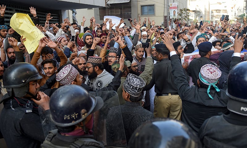 Policemen stop the protesting activists in Karachi on Friday. — AFP