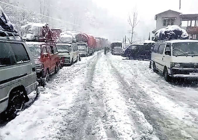 Vehicles on their way to Chitral parked in Panakot, Upper Dir, as Lowari tunnel road was closed on Wednesday due to heavy snowfall. &mdash; Dawn