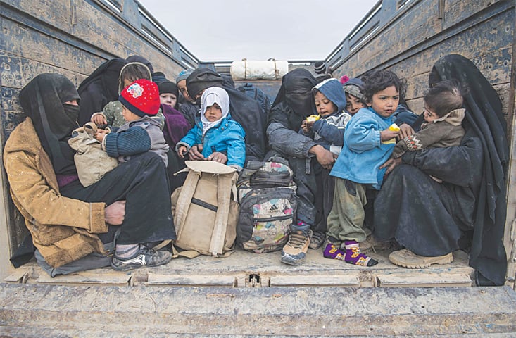 Woman and children who fled the militant Islamic State group&rsquo;s embattled holdout of Baghouz on Thursday, wait in the back of a truck in the eastern Syrian province of Deir Ezzor. &mdash;AFP