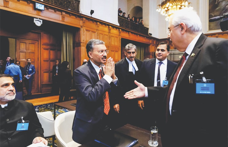 THE HAGUE: Deepak Mittal, a joint secretary in India’s ministry of external affairs, avoids shaking hands with Pakistan’s Attorney General Anwar Mansoor Khan and responds to the greeting by clasping his hands prior to the hearing of the case at the International Court of Justice on Monday.—AFP