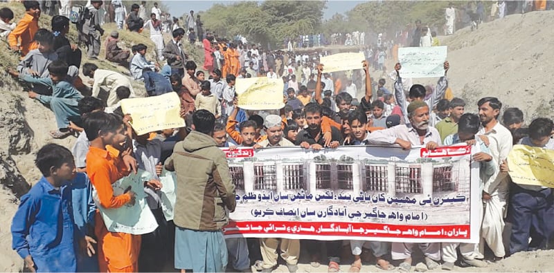 GROWERS along with their children pass through a dried up watercourse during their protest in Badin district on Tuesday.&mdash;Dawn