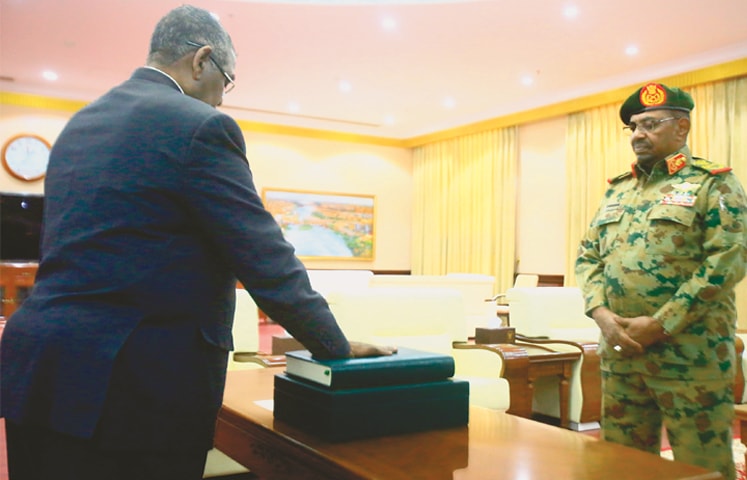 Khartoum: Sudanese President Omar al Bashir (right) watches as Mohamed Tahir Ela, a former governor of the agricultural state of Jazeera, is sworn in as the new prime minister at a ceremony at the presidential palace on Sunday.—AFP