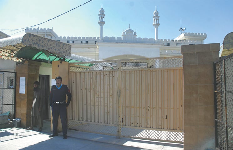 A policeman stands at the entrance of Masjid Quba following directives of the government to take over assets of proscribed organisations.—Tanveer Shahzad / White Star