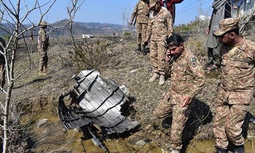 Pakistani soldiers stand next to the wreckage of an Indian fighter jet shot down on February 27, 2019, in Bhimbar district near the Line of Control. — ISPR/File