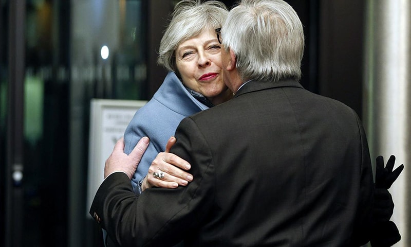 British Prime Minister Theresa May, background, is welcomed by European Commission President Jean-Claude Juncker in Strasbourg, France.—AP