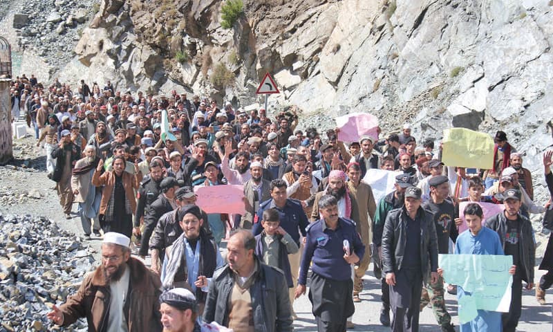 Protesters holding placards march on Karakoram Highway at Glozeband on Friday. — Dawn Protesters holding placards march on Karakoram Highway at Glozeband on Friday. — Dawn