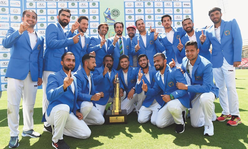 DEHRADUN: Afghanistan players pose with the trophy after winning the Test against Ireland at the Rajiv Gandhi International Cricket Stadium on Monday.—AFP