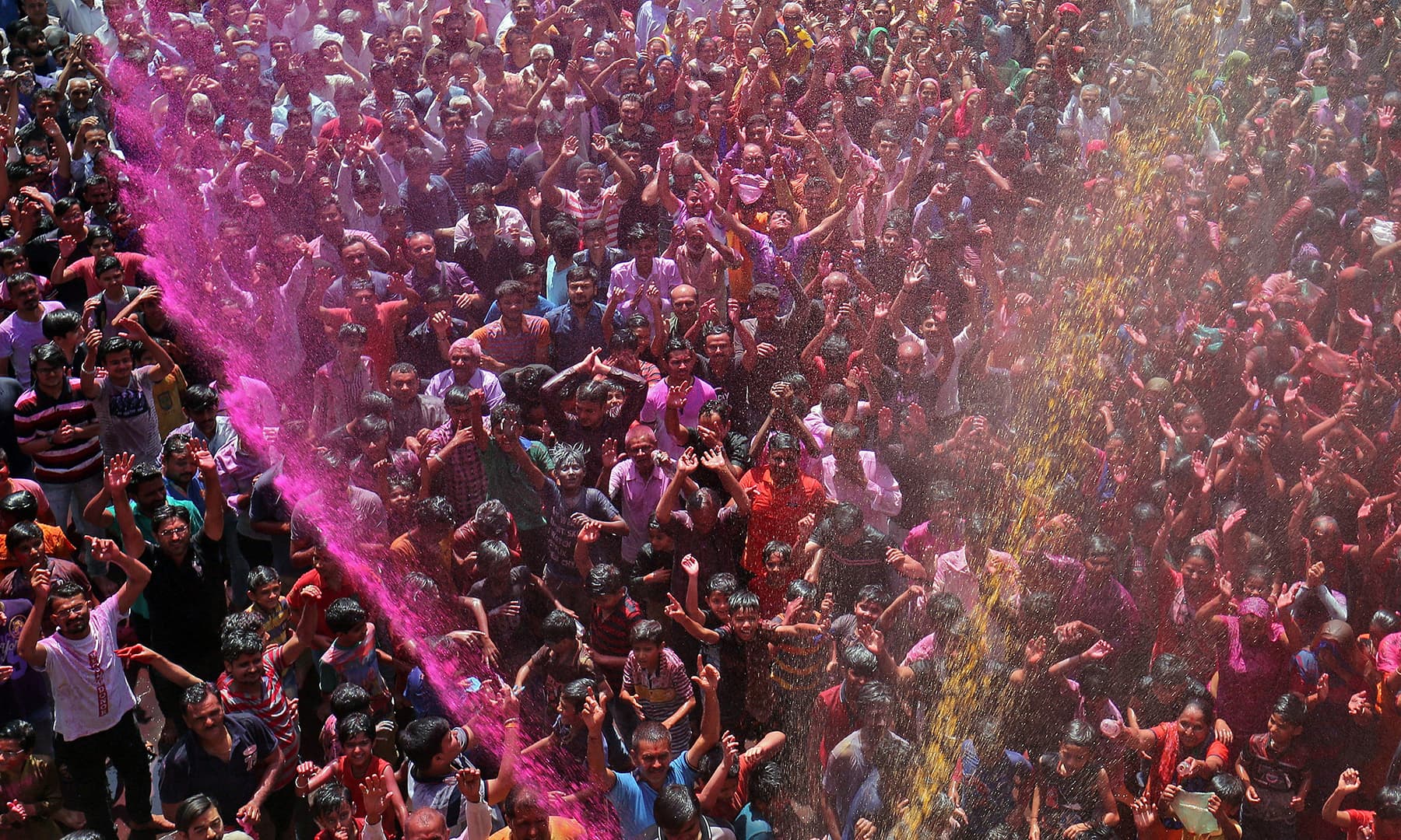 Hindu devotees pray as they are sprayed with colours by a priest on a temple premises during Holi celebrations in Ahmedabad, India, March 20, 2019. &mdash; Reuters