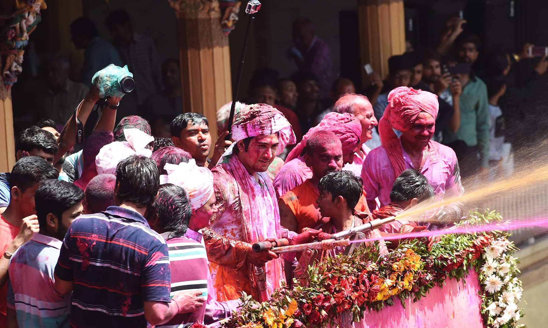 Indian heir to Kalupur Swaminarayan Temple Lalji Maharaj Shri Vrajendraprasdaji Maharaj (C) sprays coloured water on Hindu devotees as they celebrate the Holi festival at the Kalupur Swaminarayan Temple in Ahmedabad on March 20, 2019. &mdash; AFP