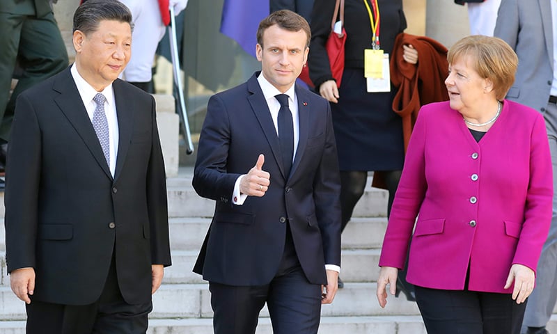 French President Emmanuel Macron (C) gestures next to German Chancellor Angela Merkel (R) and Chinese President Xi Jinping (L) following their meeting at the Elysee Palace in Paris on Tuesday. &mdash; AFP