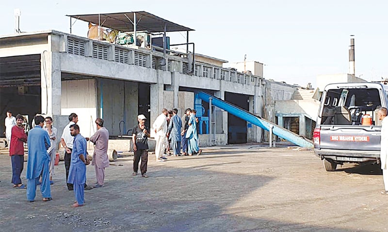 PEOPLE gather outside the factory where the deaths occurred in the Ibrahim Hyderi area on Monday.&mdash;PPI
