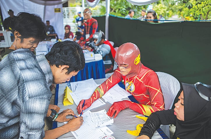 SURABAYA (Indonesia): Election workers dressed in superhero costumes register voters at a polling station on Wednesday. Indonesia held one of the world’s biggest one-day polls, pitting President Joko Widodo against ex-general Prabowo Subianto in a race to lead the Muslim-majority nation. Mr Widodo won a second five-year term in a victory for moderation over the nationalistic rhetoric of Mr Subianto.—AFP