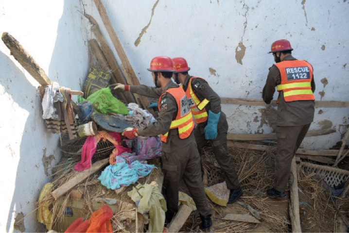 Rescue workers remove household items from the debris after the roof of a house collapsed in Behram Dheri area of Charsadda on Thursday. — White Star