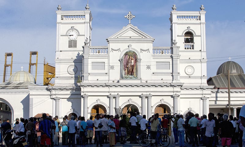 People gather outside St Anthony's Shrine a day after a blast targeted it. ─ AP