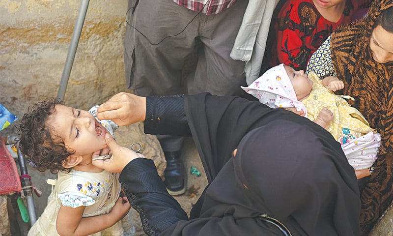 A health worker administering polio drops to a child in Karachi.—Fahim Siddiqi / White Star