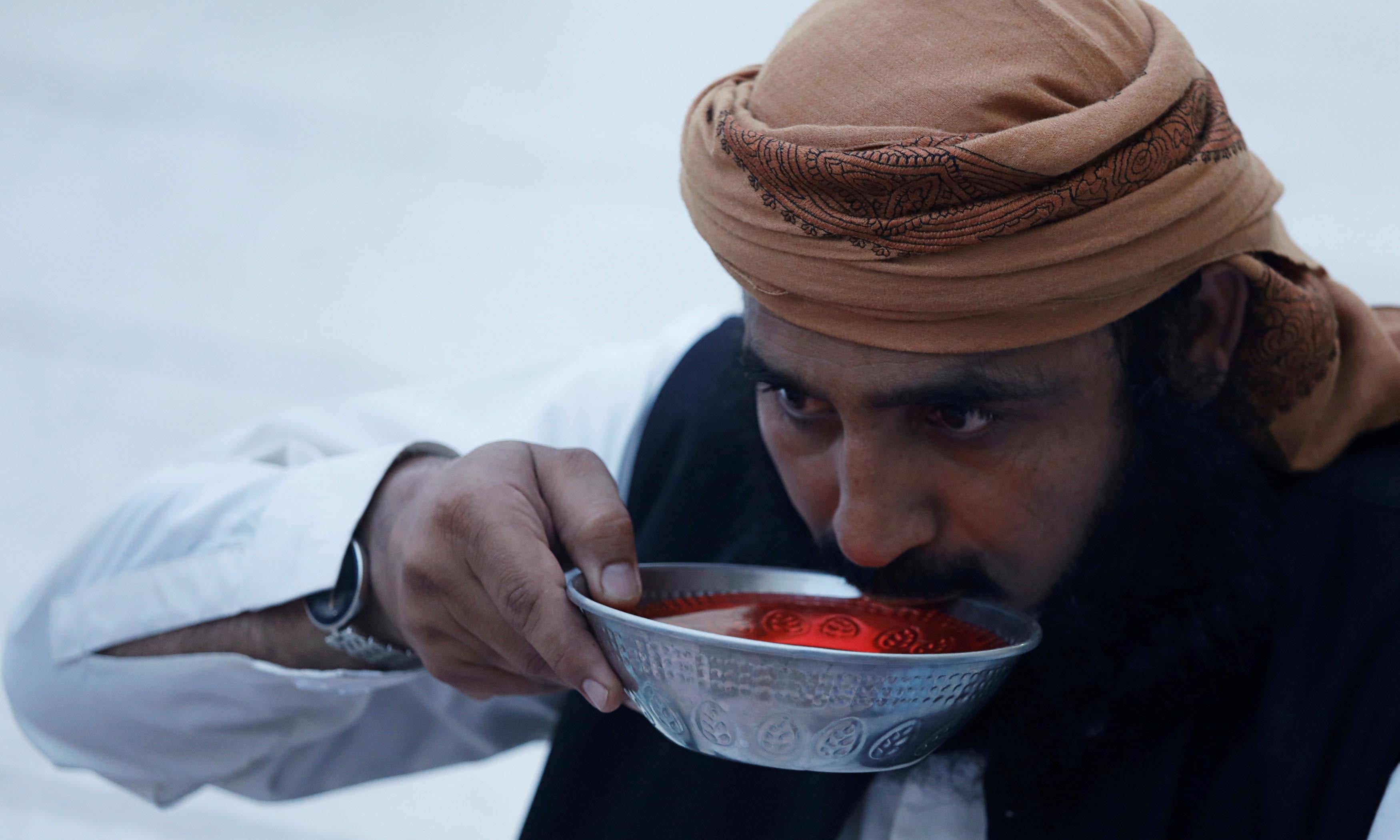 A man takes a sip from a bowl of syrup as he breaks his fast in Peshawar.— Reuters