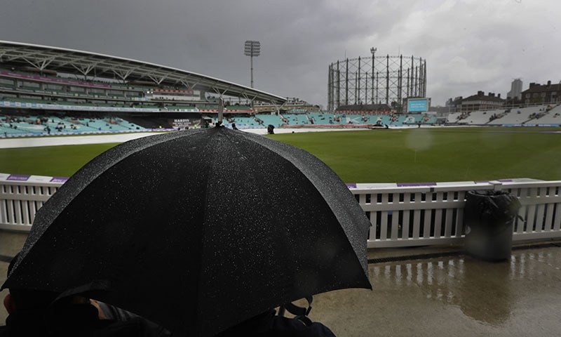 Members of the public shelter under an umbrella as rain delays the start of play of the first One Day International cricket match between England and Pakistan at The Oval in London, Wednesday, May 8, 2019. (AP Photo/Kirsty Wigglesworth) &mdash; Copyright 2019 The Associated Press. All rights reserved