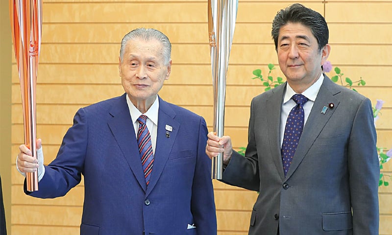 JAPANESE Prime Minister Shinzo Abe (R) and Tokyo 2020 Olympic and Paralympic games organising committee president Yoshiro Mori pose while holding the Olympic torches at Abe’s official residence on Thursday.—AFP