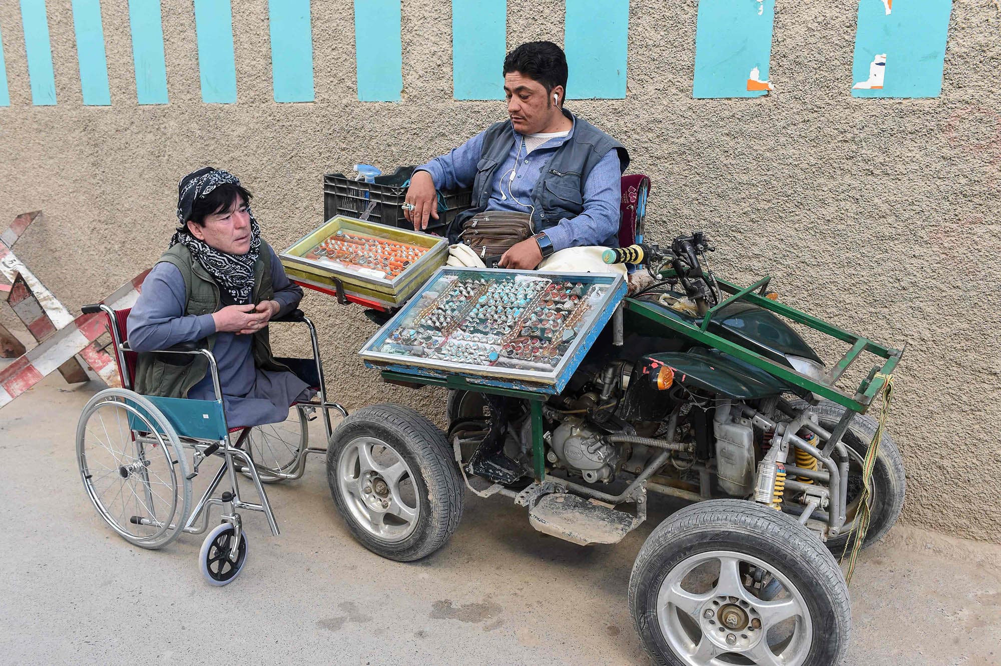 In this picture taken on May 3, 2019, a disabled vendor (R) belonging to the Hazara community waits for customers at a roadside in Quetta's Hazara Town. — AFP