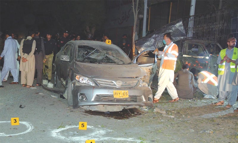 QUETTA: Rescue workers gather at the scene of the bomb blast in Satellite Town here on Monday.—INP