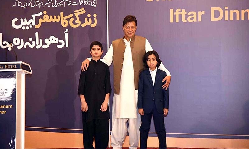 عمران خان شوکت خانم ہسپتال میں کینسر کا علاج حاصل کرنے والے 2 بچوں کے ساتھ کھڑے ہیں — فوٹو: اے پی پی