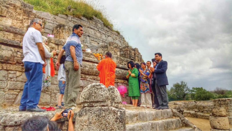 Participants perform rituals at the 3rd century BC Dharmarajika Stupa near Taxila in connection with Vesak Day. — Dawn