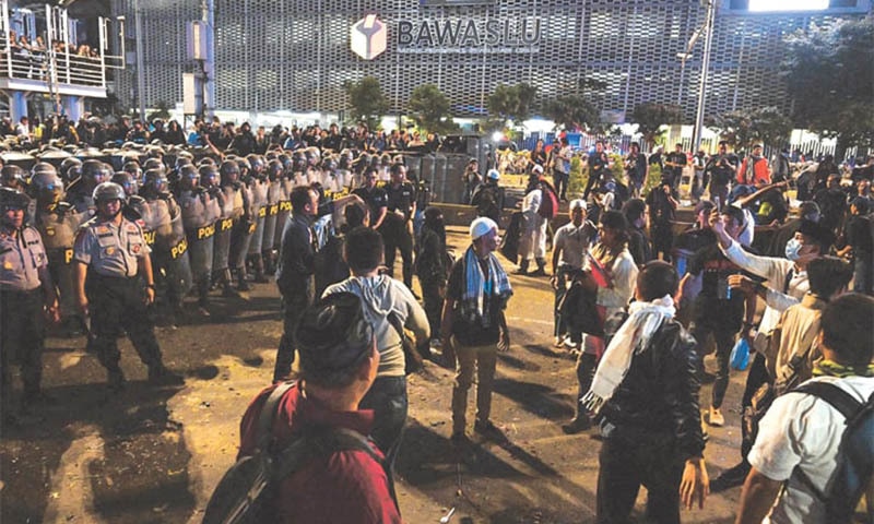 JAKARTA: Policemen line up as they face protesters during a demonstration on Tuesday outside the Elections Oversight Body amid fears of unrest in the city. — AFP