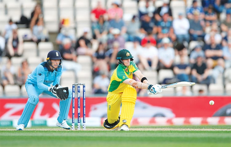 SOUTHAMPTON: Australia’s Steve Smith sweeps during his century as England’s stand-in captain Jos Buttler watches in the ICC World Cup warm-up match at the Ageas Bowl on Saturday.—Reuters