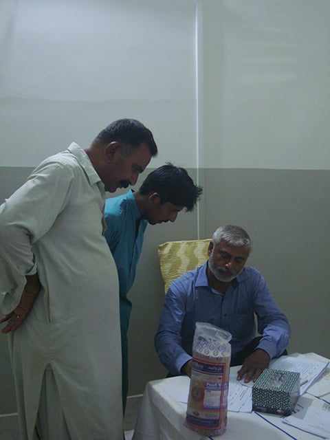 Male visitors get necessary information about HIV from a volunteer at the screening camp.