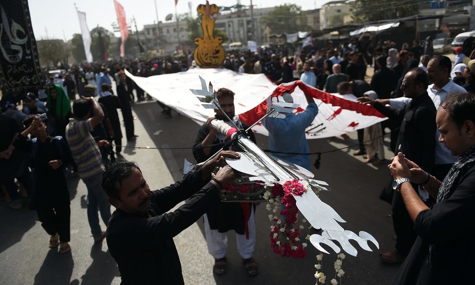 عزاداروں نے جلوس میں علم اٹھا رکھے تھے — فوٹو: اے ایف پی