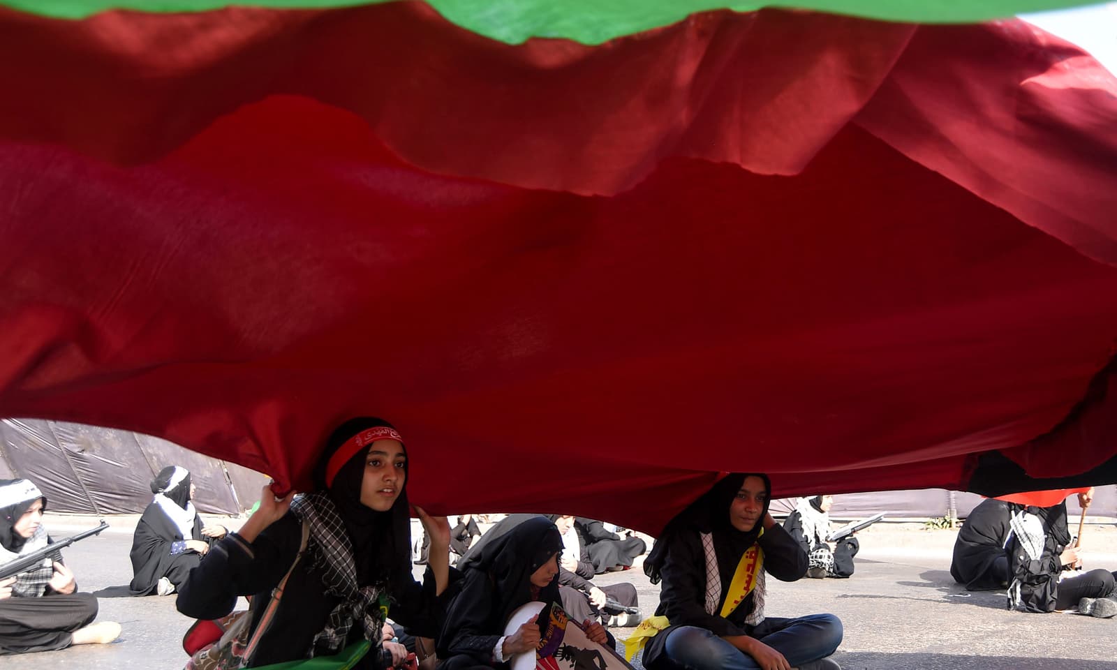 کراچی میں ریلی کے دوران خواتین نے فلسطین کا طویل جھنڈا اٹھا رکھا ہے &mdash; فوٹو: اے ایف پی