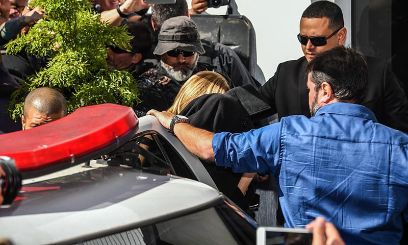 Najila Trindade Mendes de Souza (C-covered with a black jacket) arrives at the Women's Defence Precinct in Sao Paulo, Brazil on Friday. &mdash; AFP